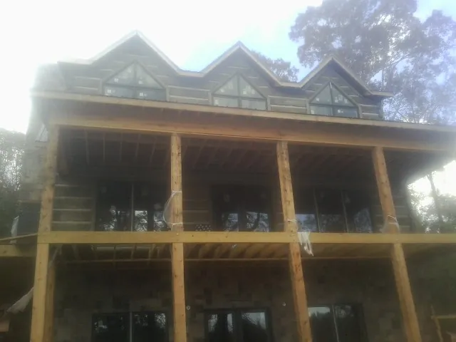 Dormers and porch framing on a large log home under construction — Roof Coating work by our crew in Johnson City